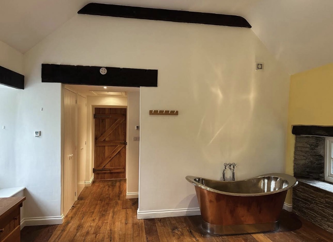 White and yellow bathroom with freestanding copper bath