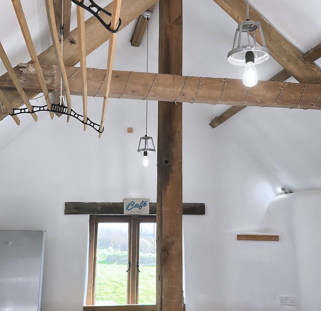 White vaulted interior with oak beams and high window
