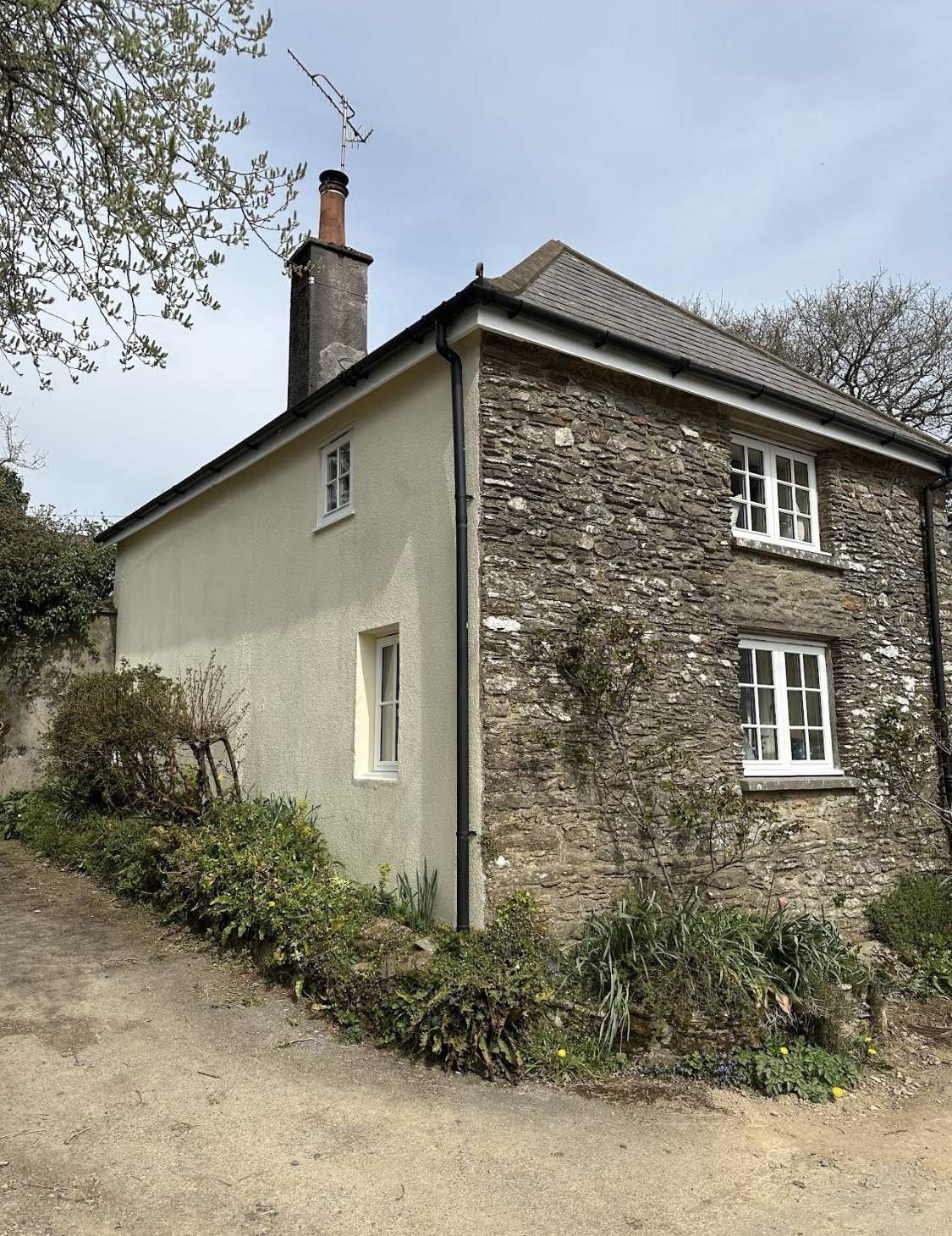 Stone cottage with rendered side wall and white window