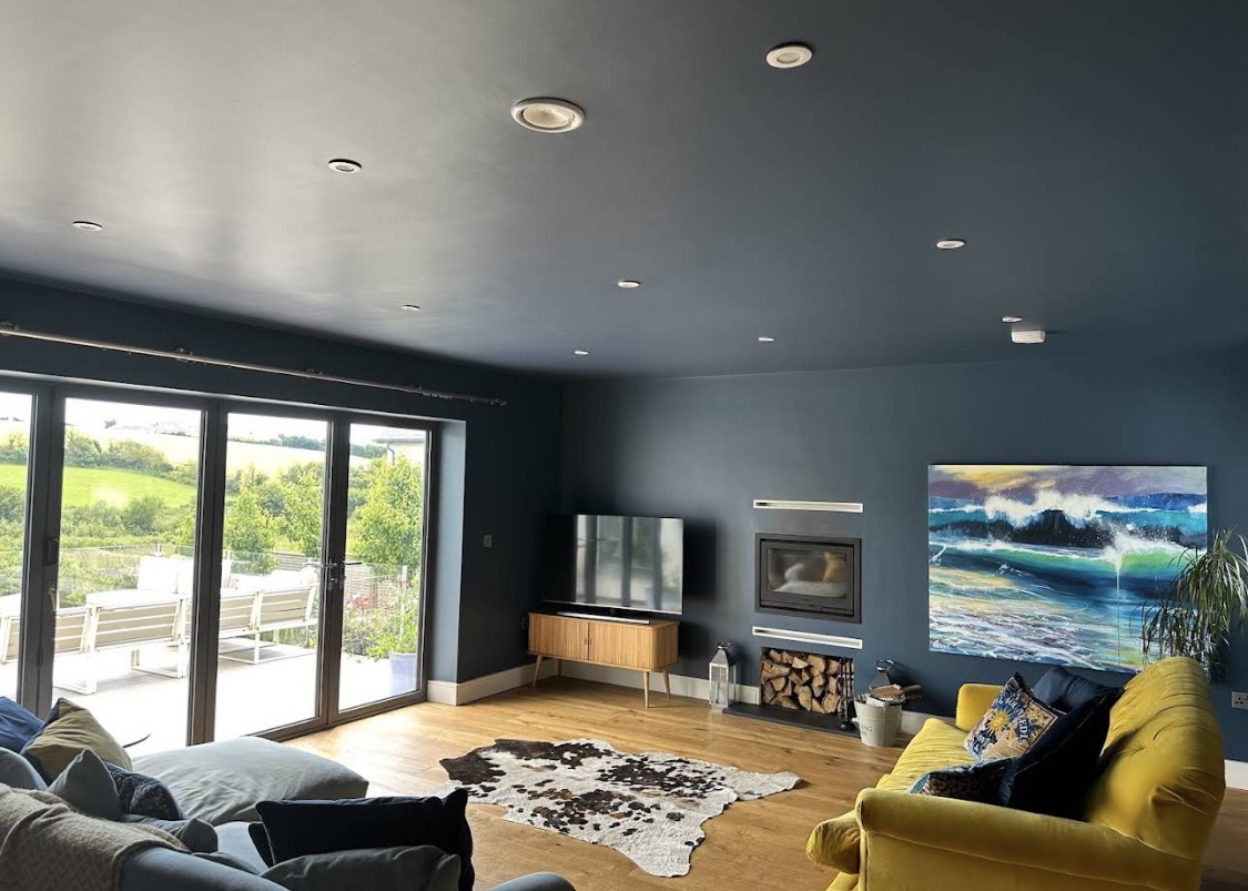 Blue living room with mustard sofa and fireplace