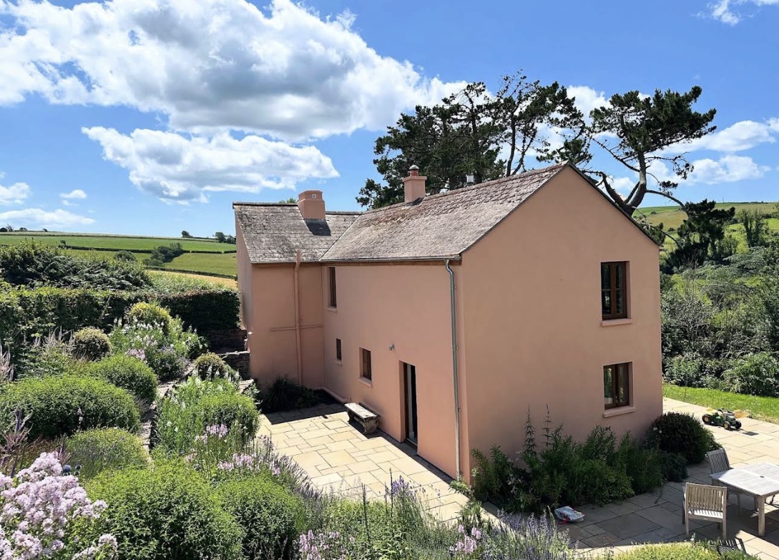 Peach-painted country house beside a garden