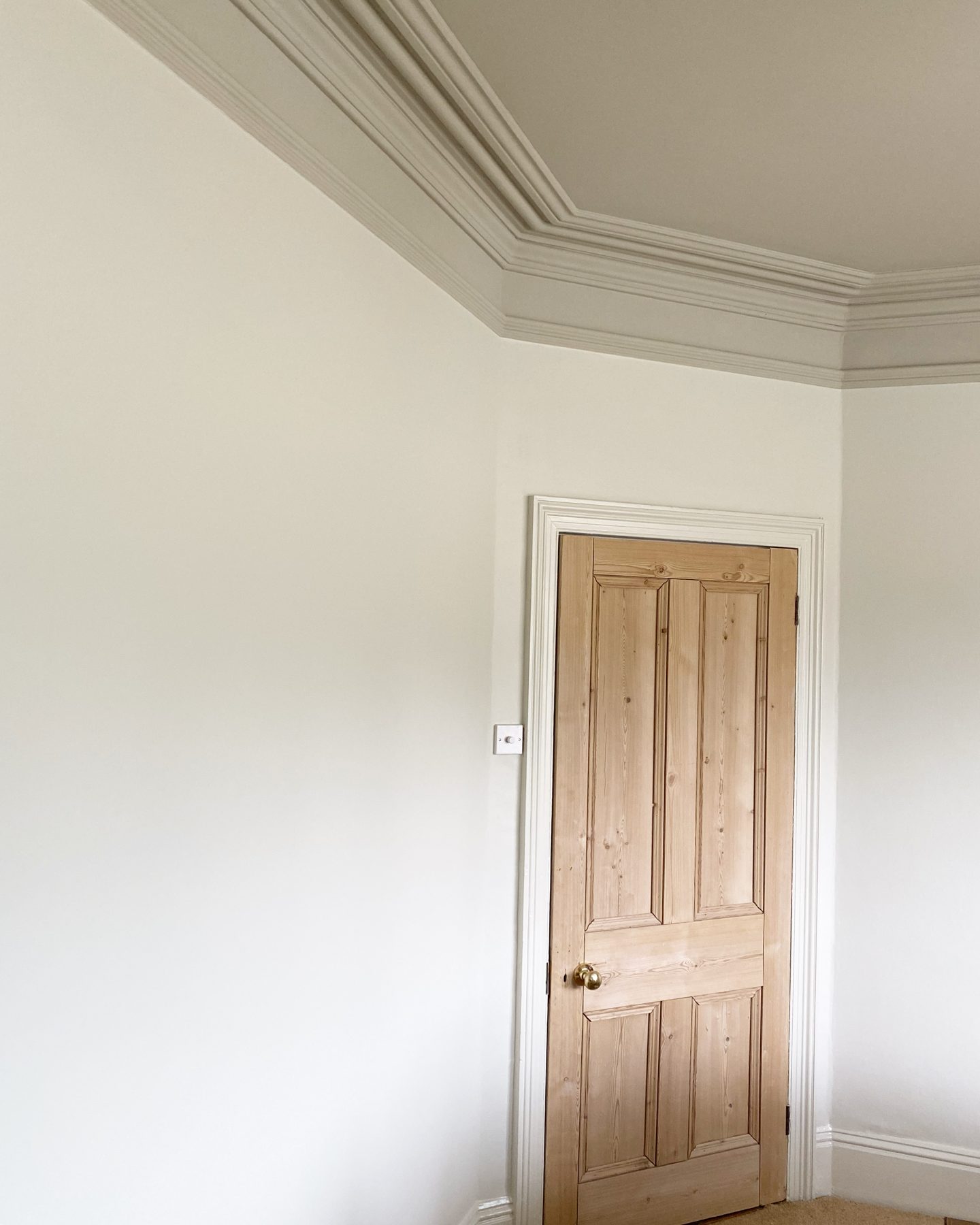 Crisp white room with oak door