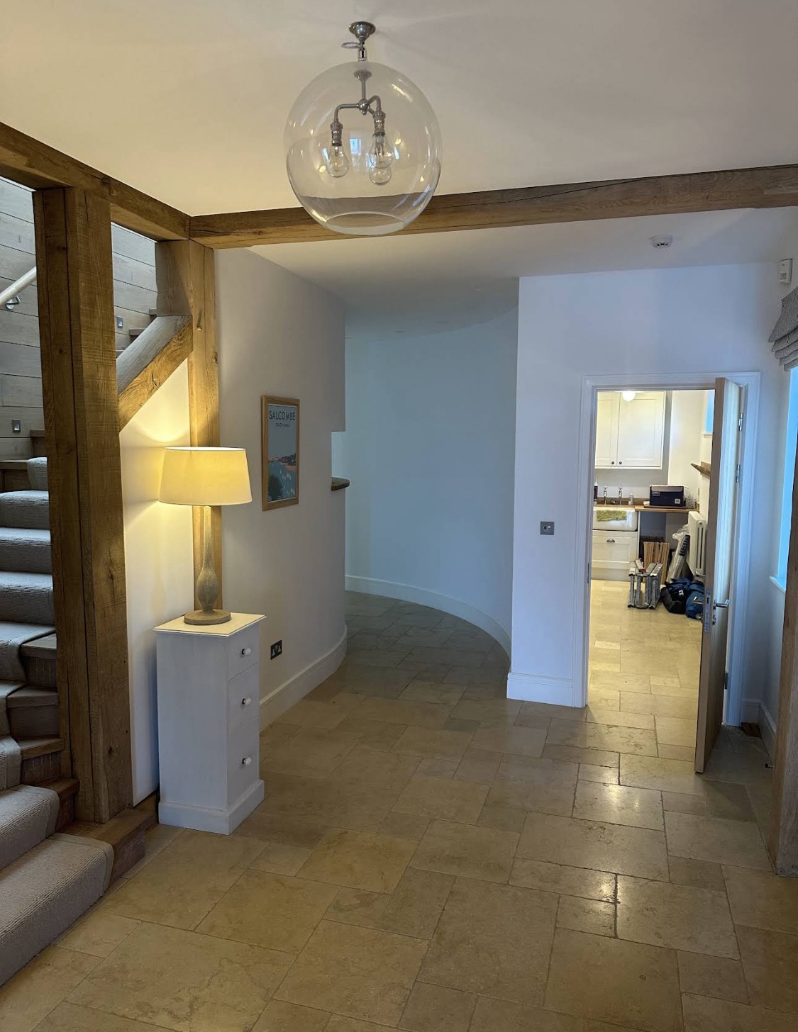 White entrance hall with oak frame — work area beyond