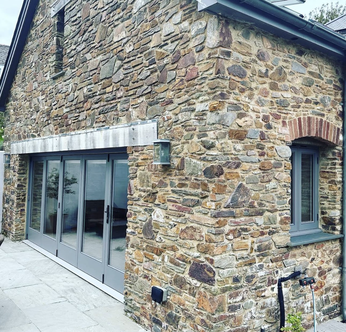 Grey painted glazed doors on a stone barn