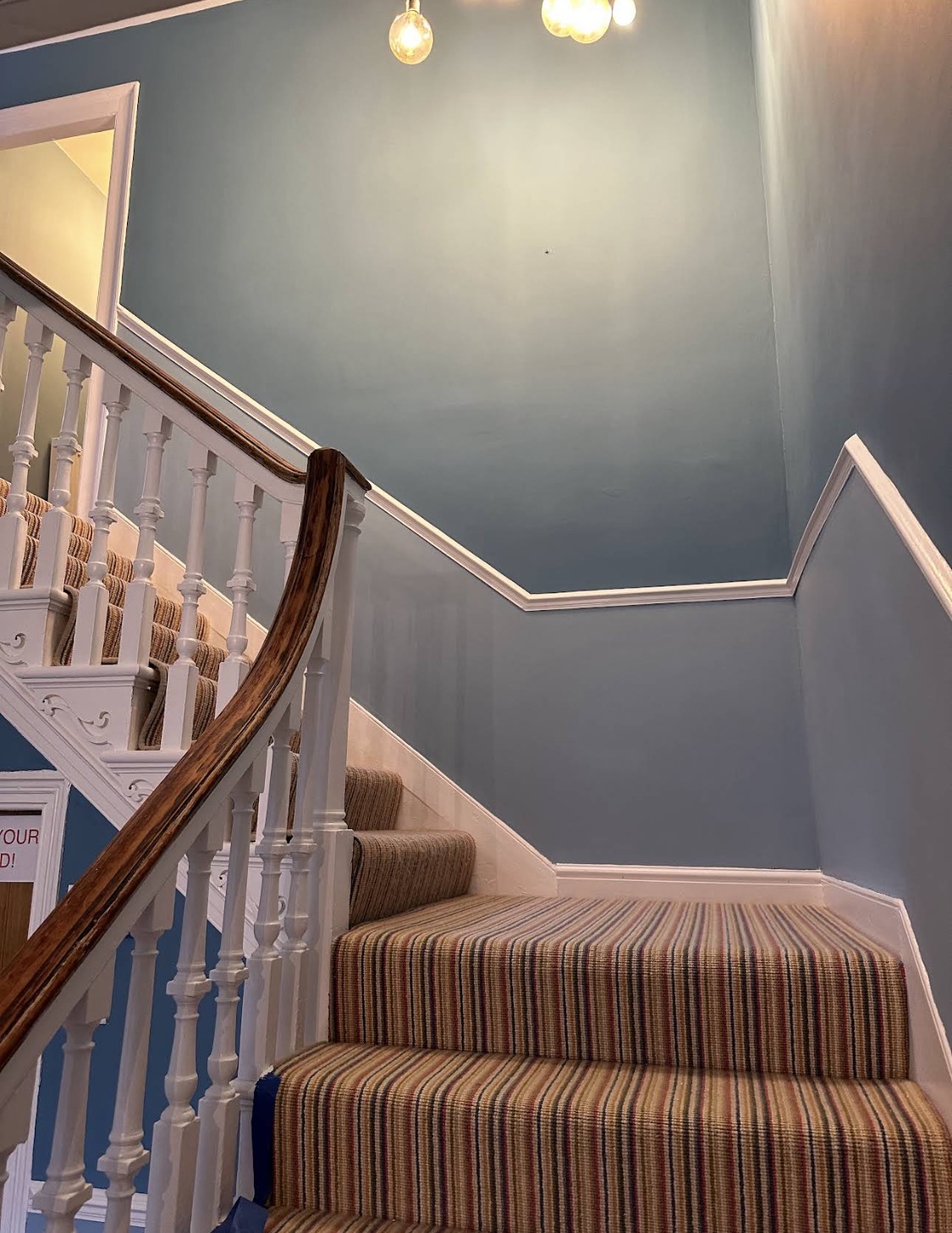 Landing view of blue walls and curved staircase