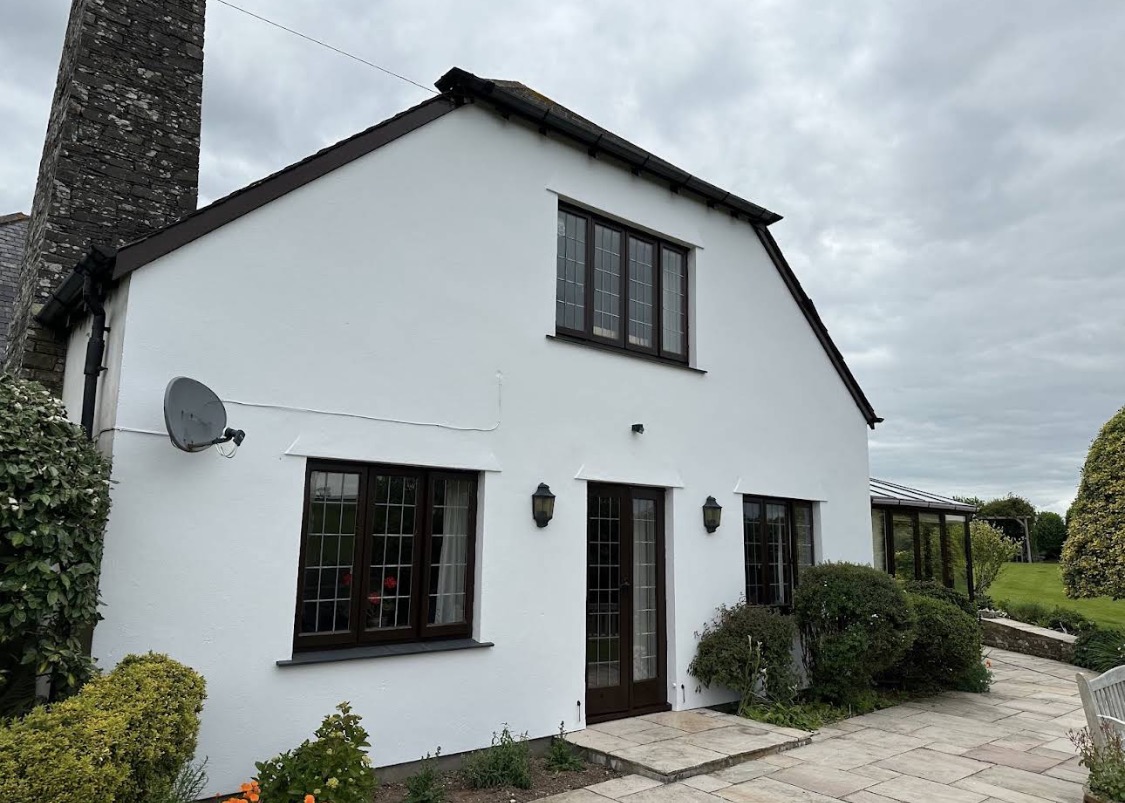 White rendered house with dark window frames