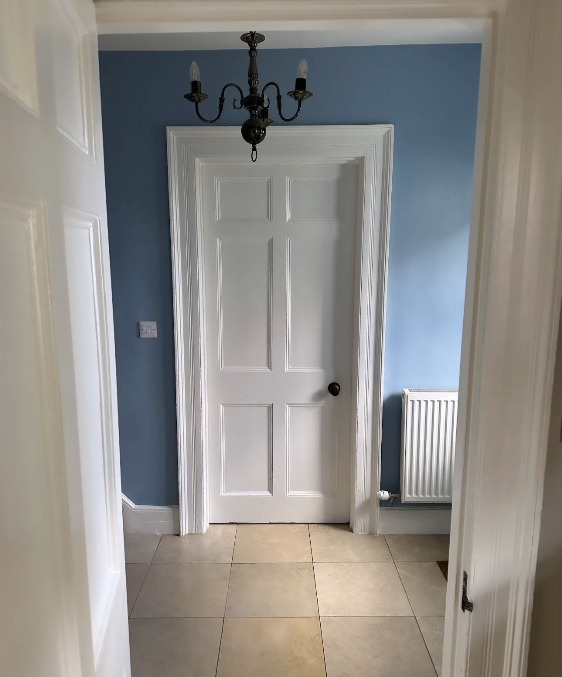 White panelled door in a blue hallway