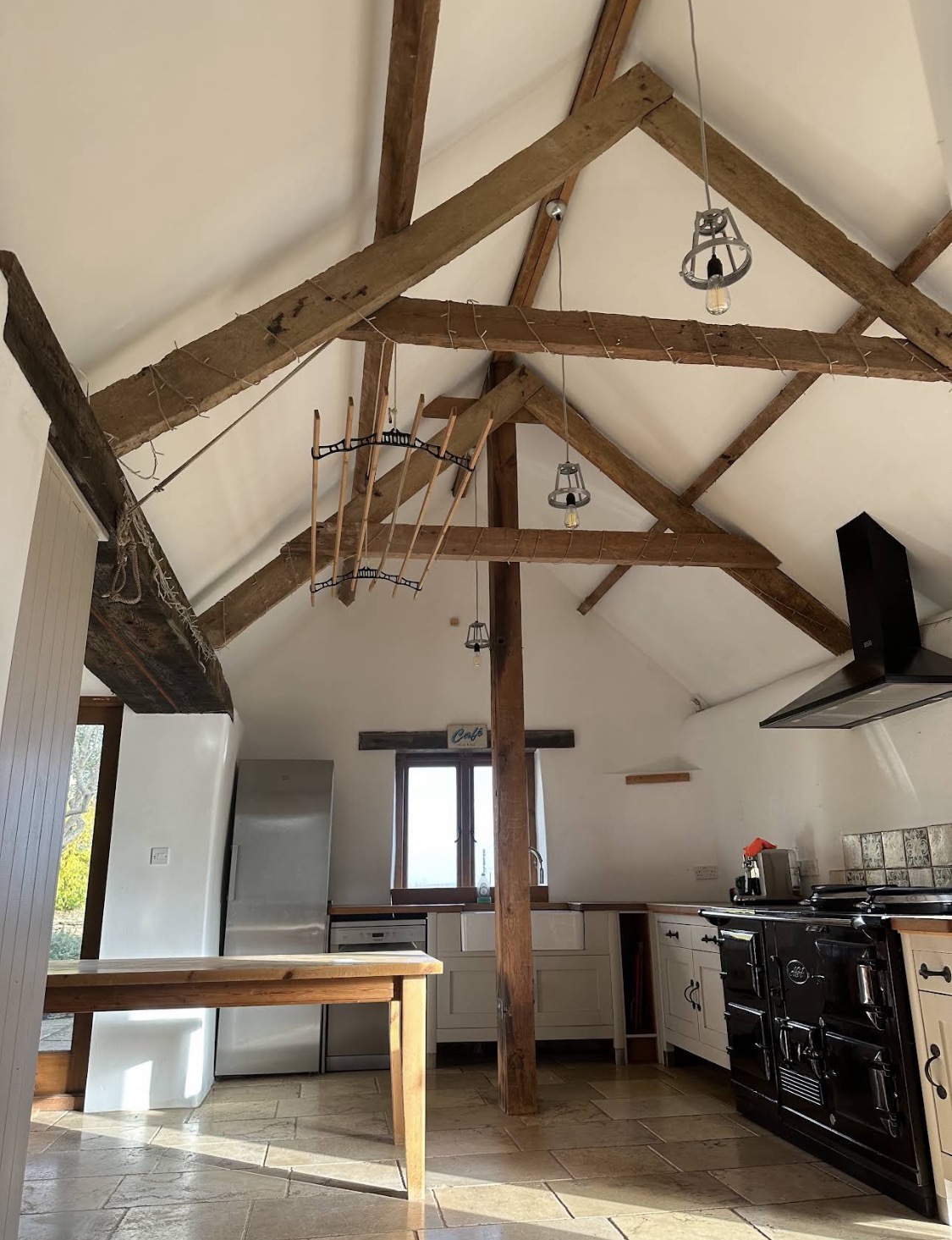 Country kitchen with vaulted white walls and exposed oak beams